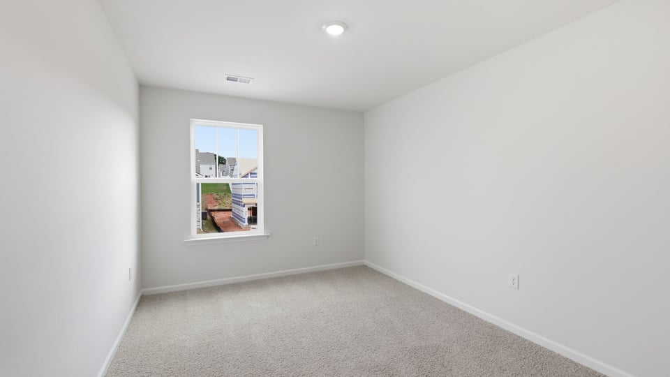 Bedroom with carpet and window.