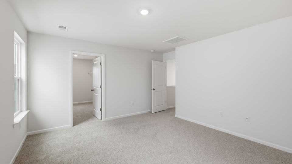 Bedroom with carpet and window.