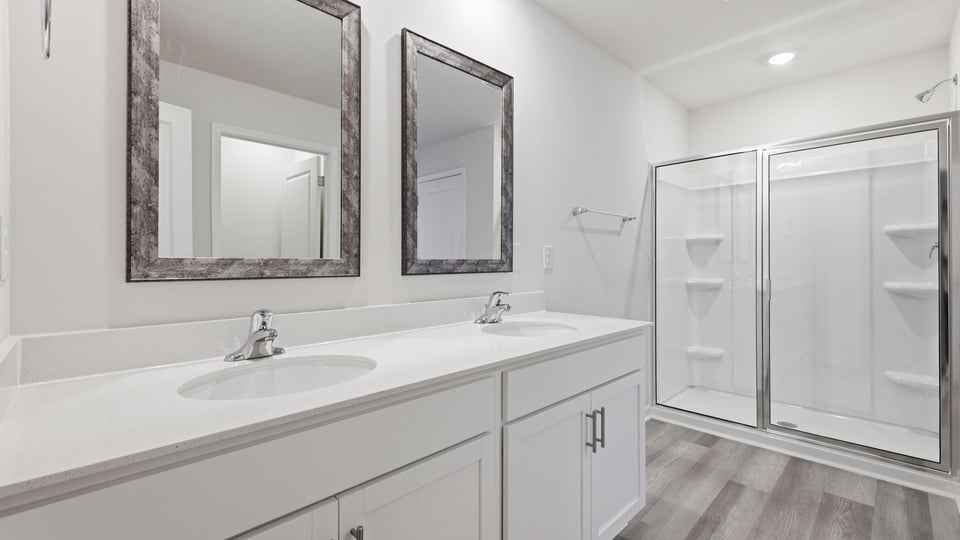 Bathroom with double vanity sink and walk in shower.