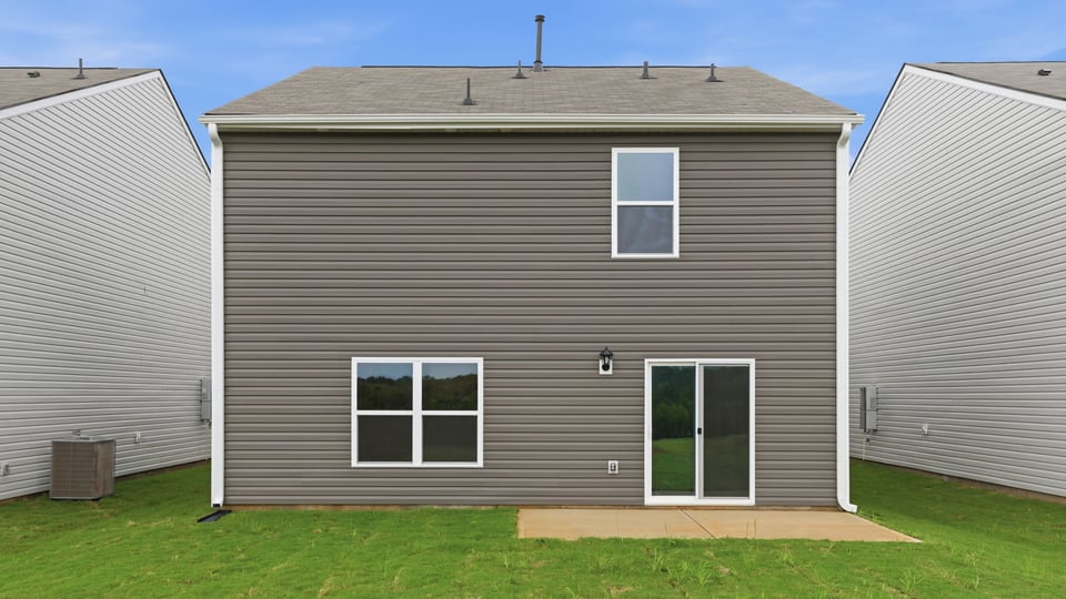 Back exterior of home with large backyard.