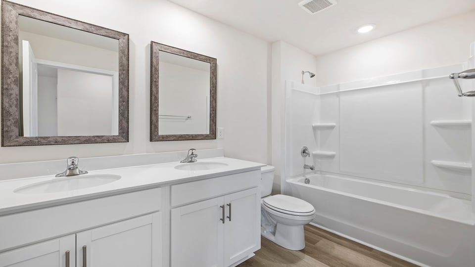 Bathroom with dual vanity and tub.