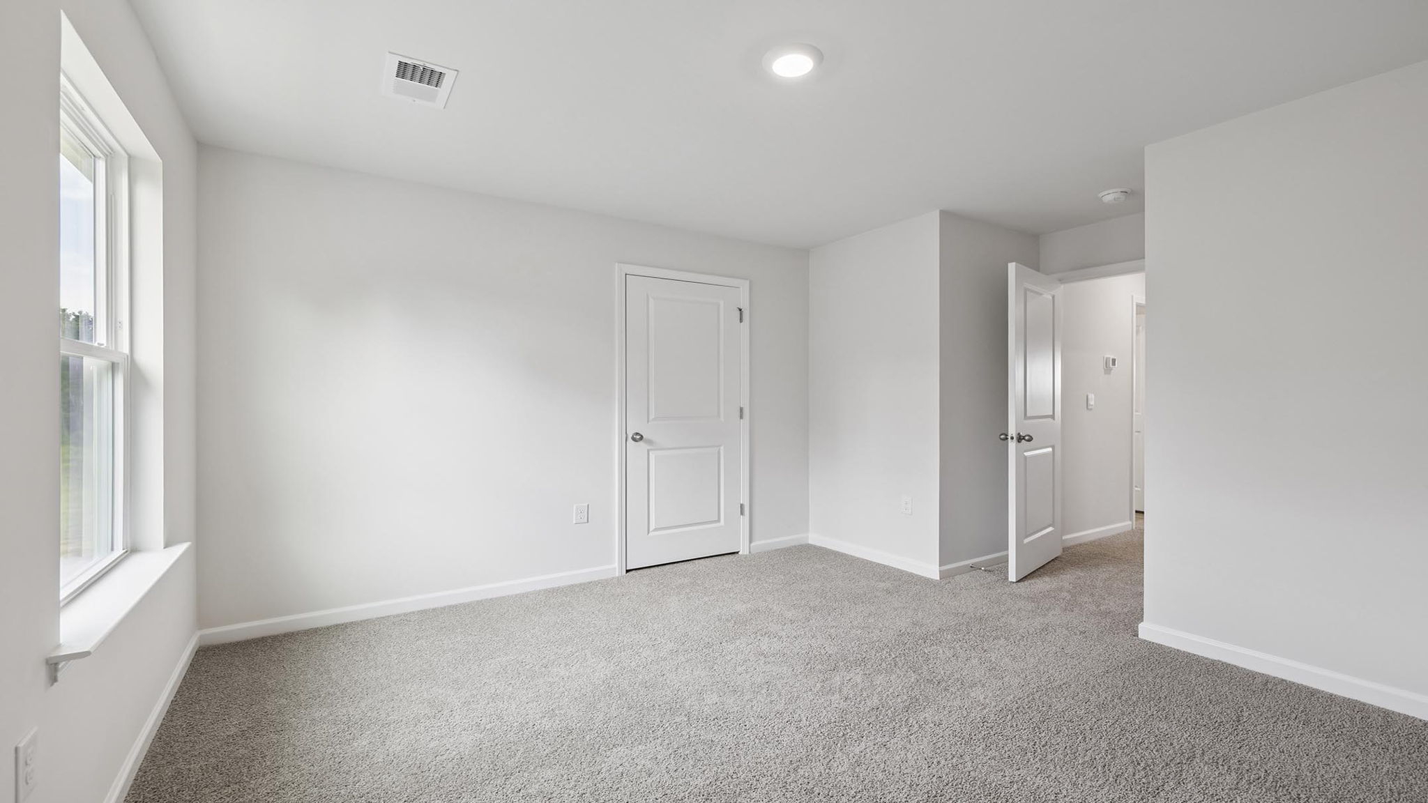 Bedroom with carpet and windows.