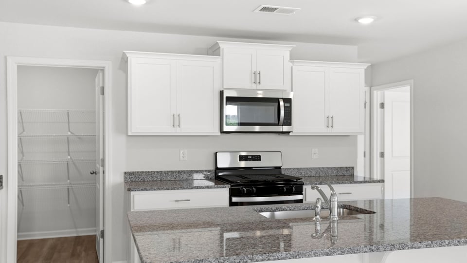Kitchen with quartz countertops and stainless steel appliances.