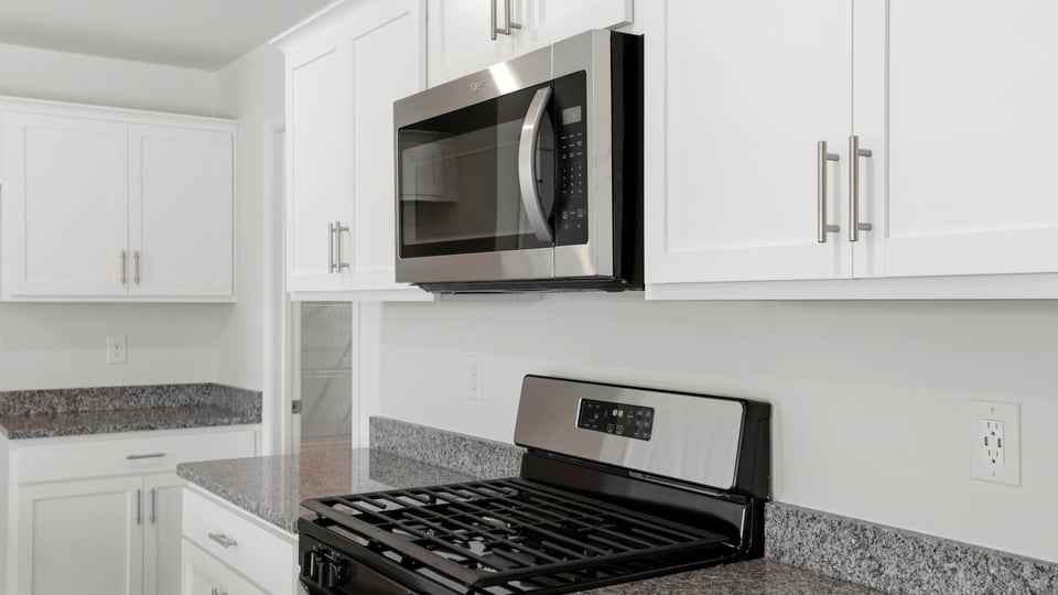 Kitchen with quartz countertops and stainless steel appliances.