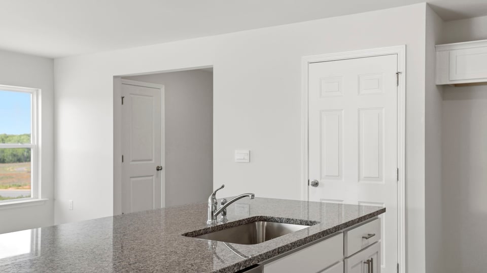 Kitchen with quartz countertops and stainless steel appliances.
