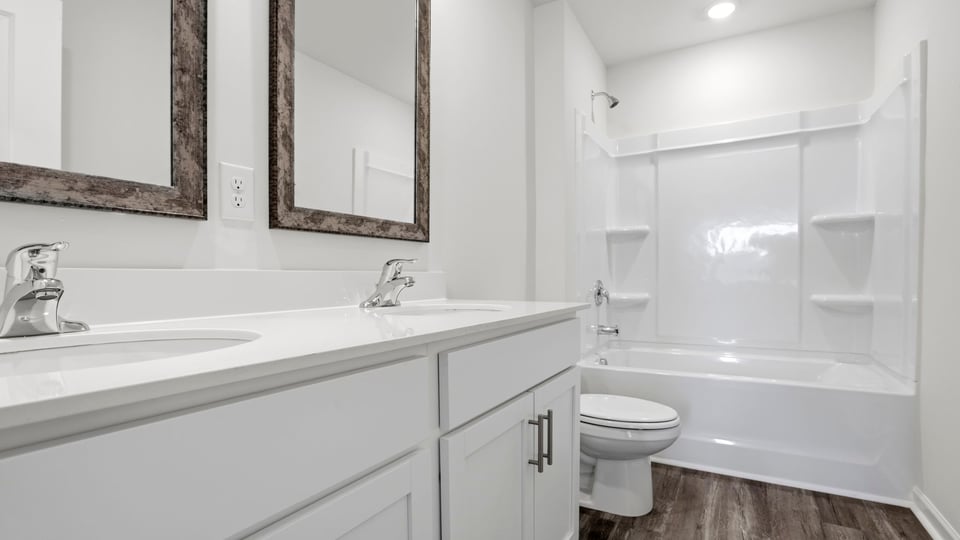 Bathroom with double vanity sink and shower.
