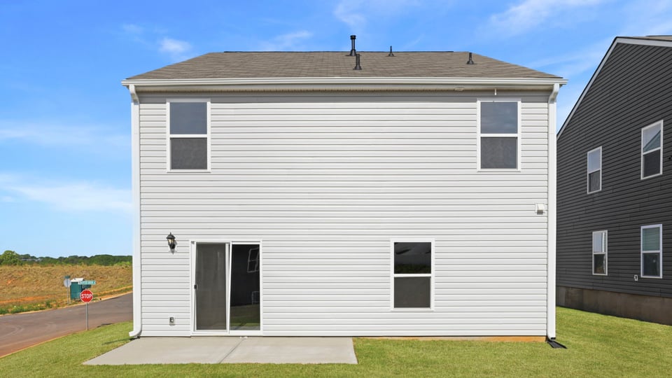 Back exterior of home with large backyard.