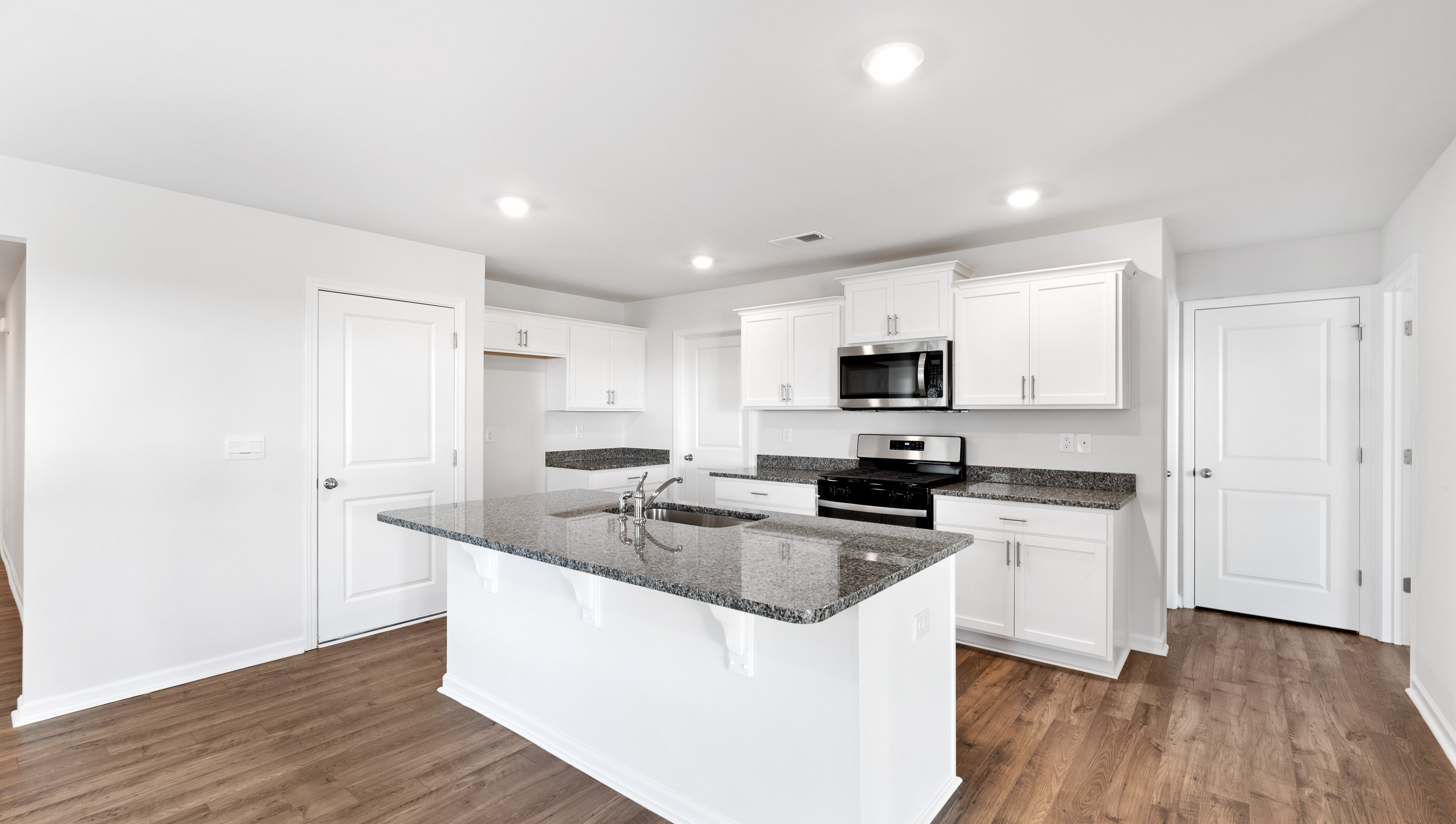 Kitchen with island and granite countertops.