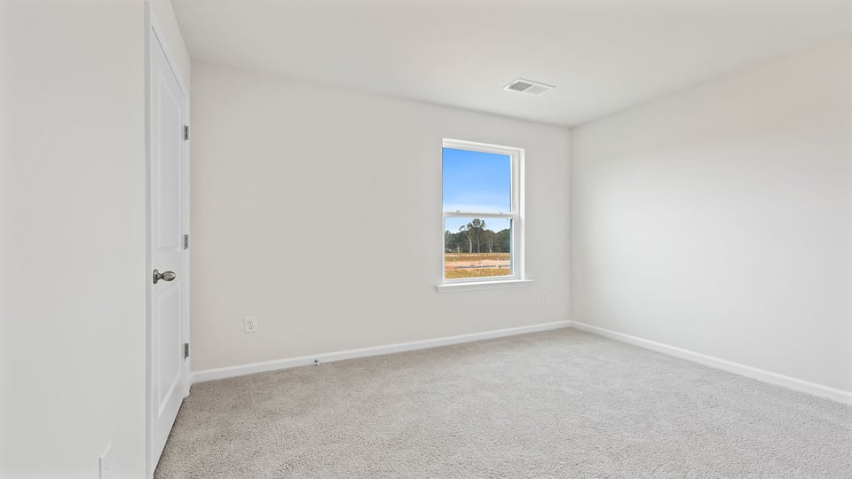 Bedroom with carpet and window.