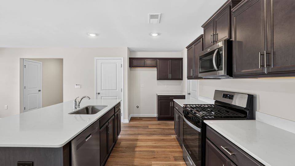 Kitchen with island and quartz countertops.