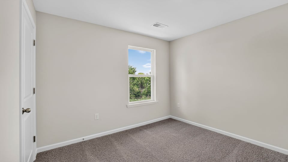 Bedroom with carpet and window.