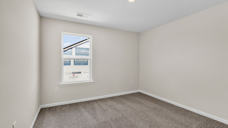 Bedroom with carpet and window.