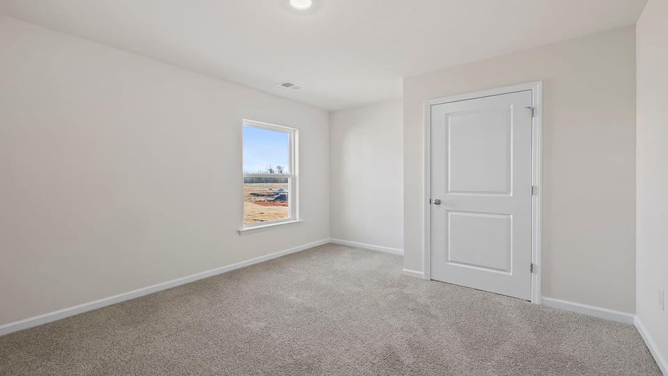 Bedroom with carpet and window.