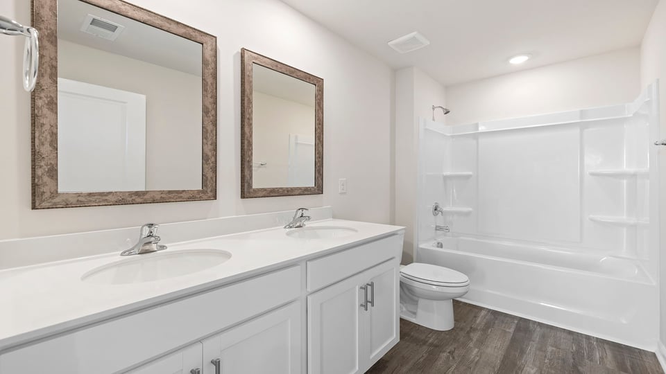 Bathroom with dual vanity and tub.