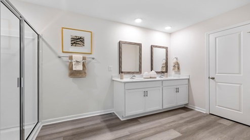 Bathroom with double vanity sink and shower.