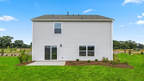 Back exterior of home with large backyard.