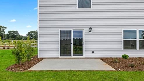 Back exterior of home with large backyard.