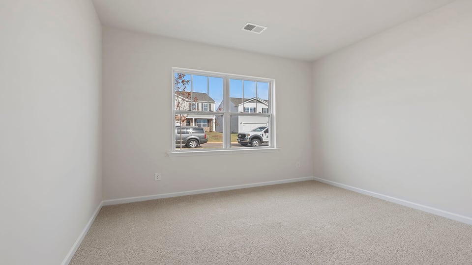 Bedroom with carpet and window.