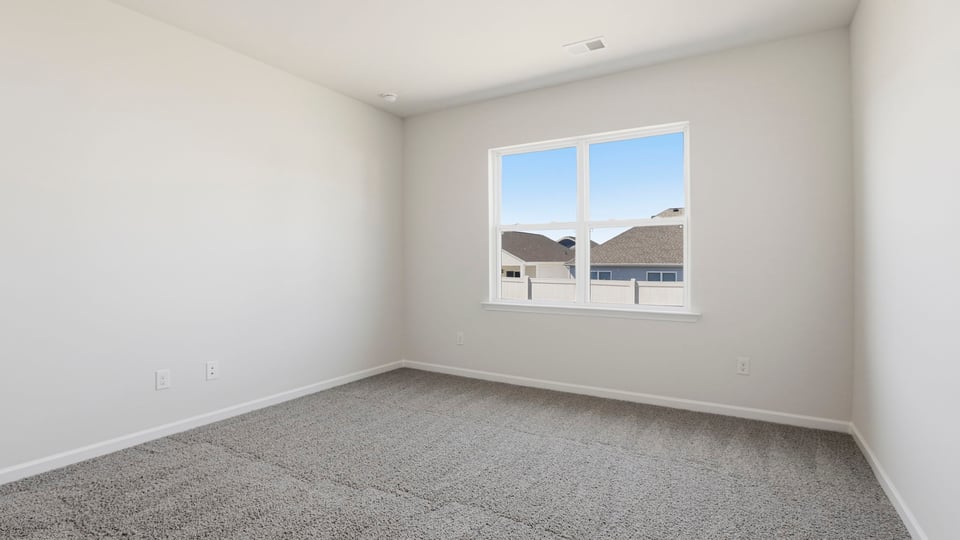 Bedroom with carpet and window.