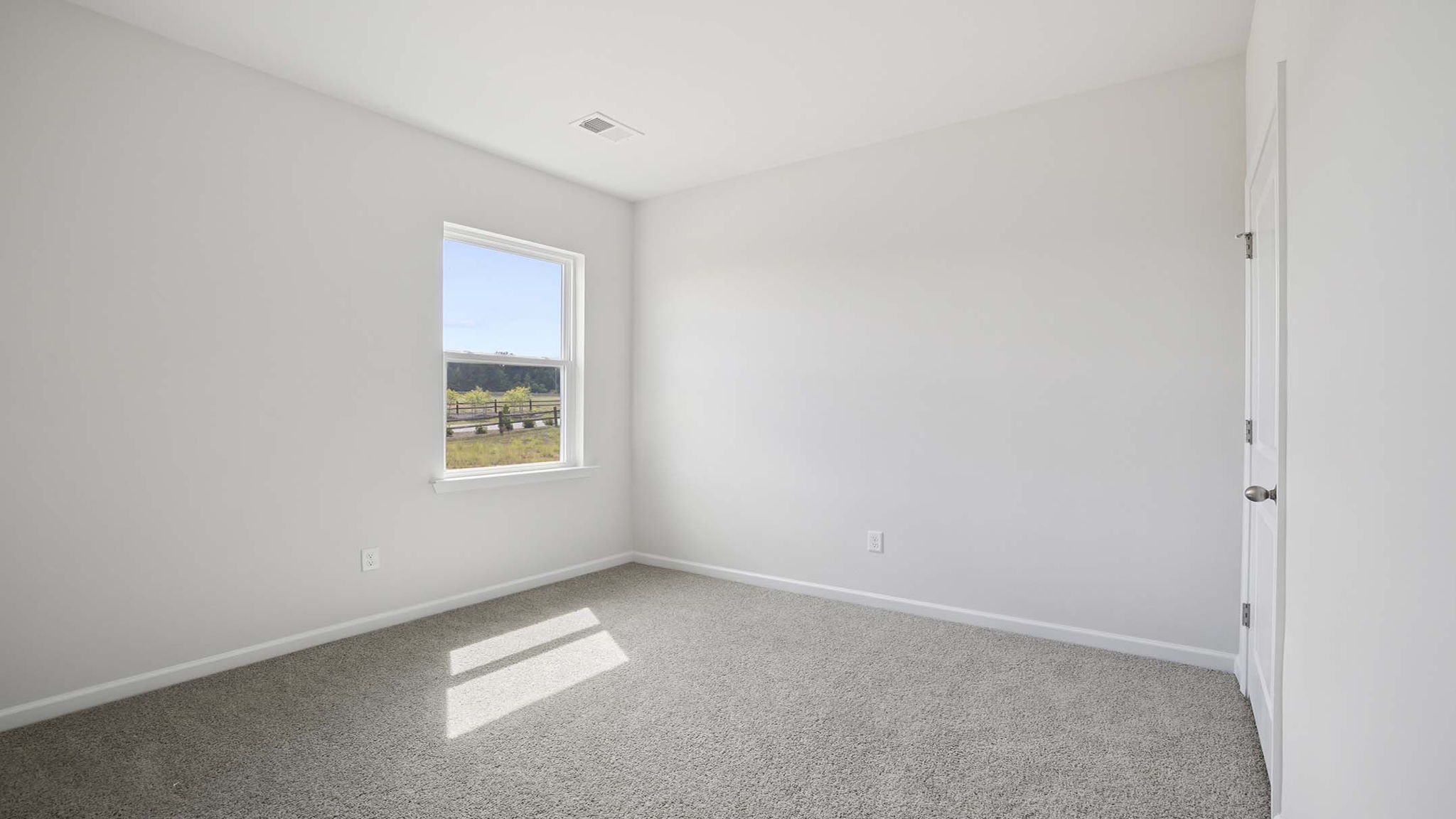Bedroom with carpet and windows.