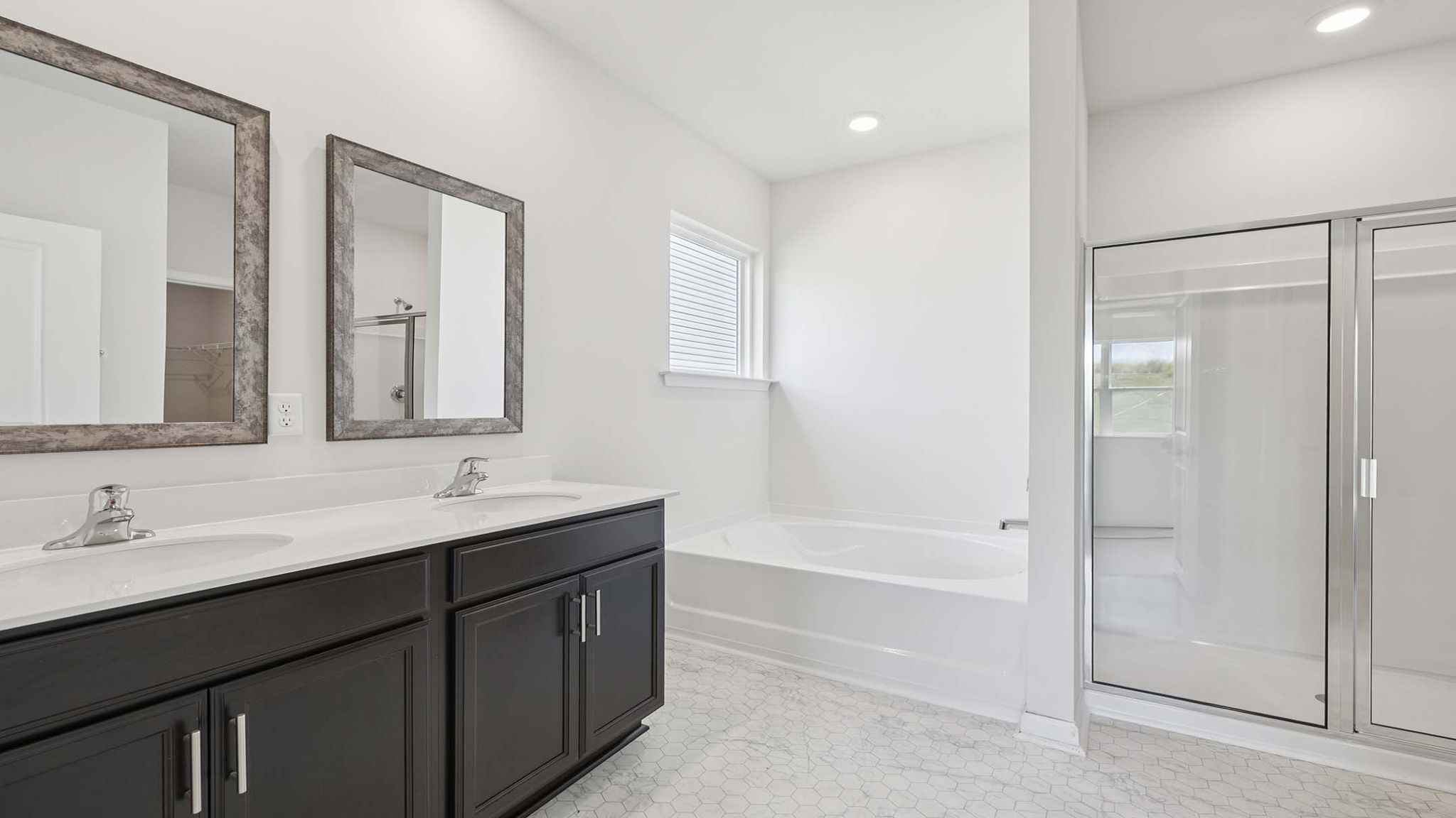 Bathroom with dual vanity, walk in shower and tub.