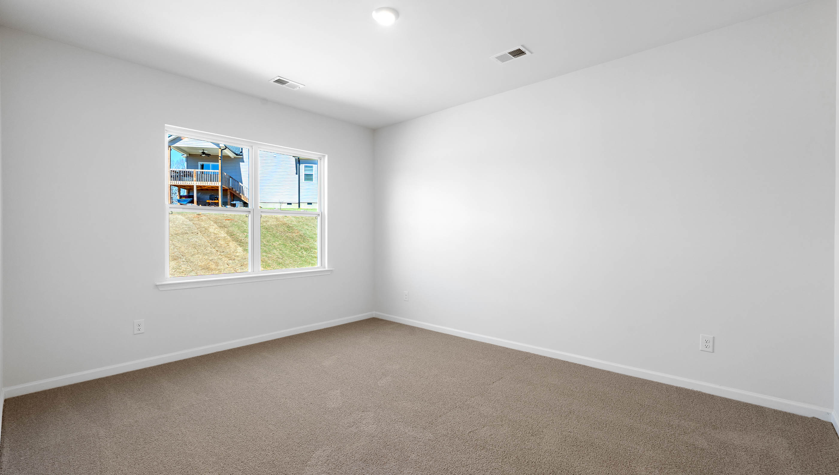 Bedroom with carpet and windows.