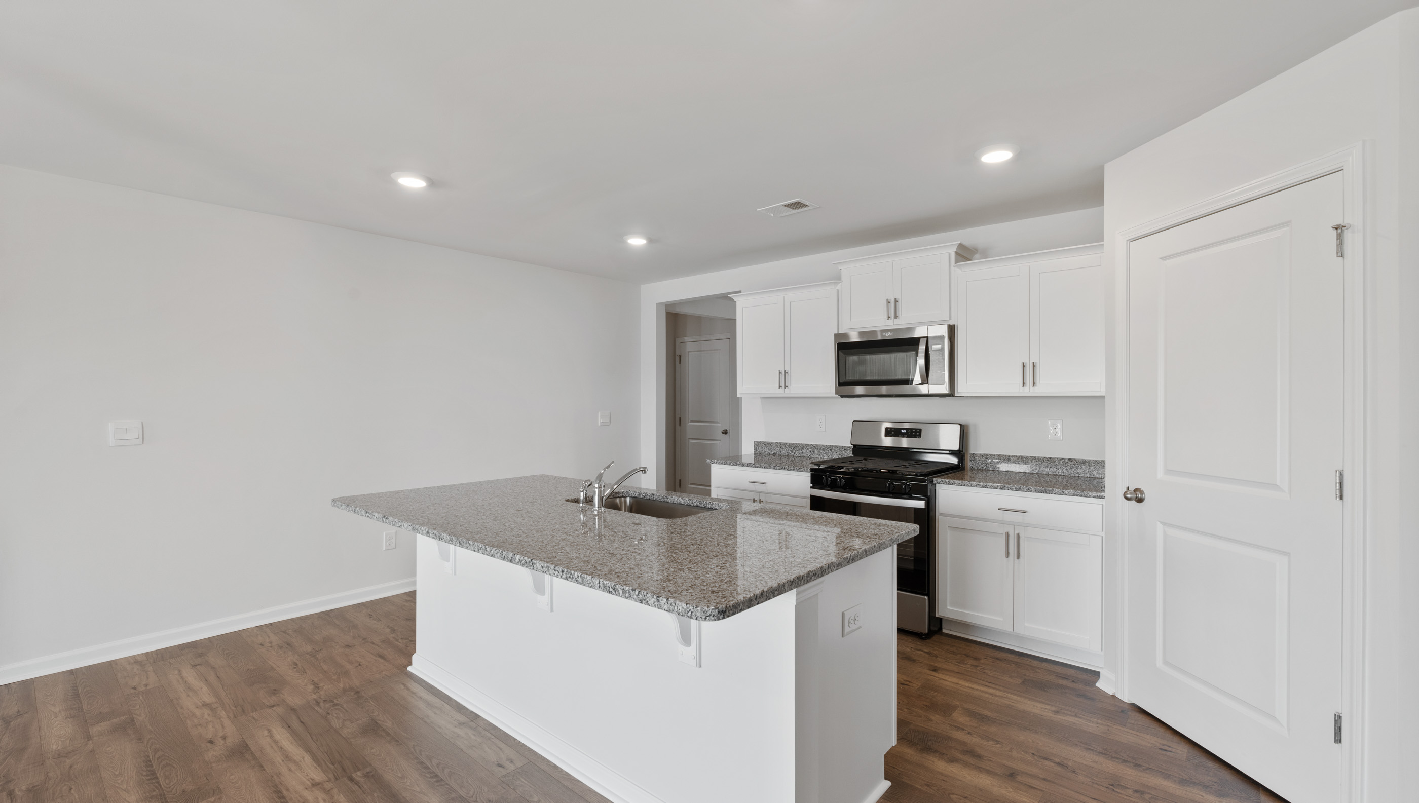 Kitchen and island with granite counter tops.