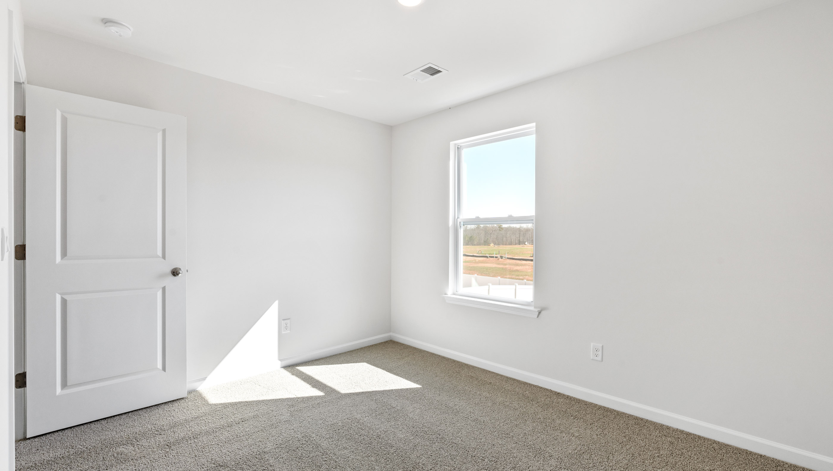 Bedroom with carpet and window.