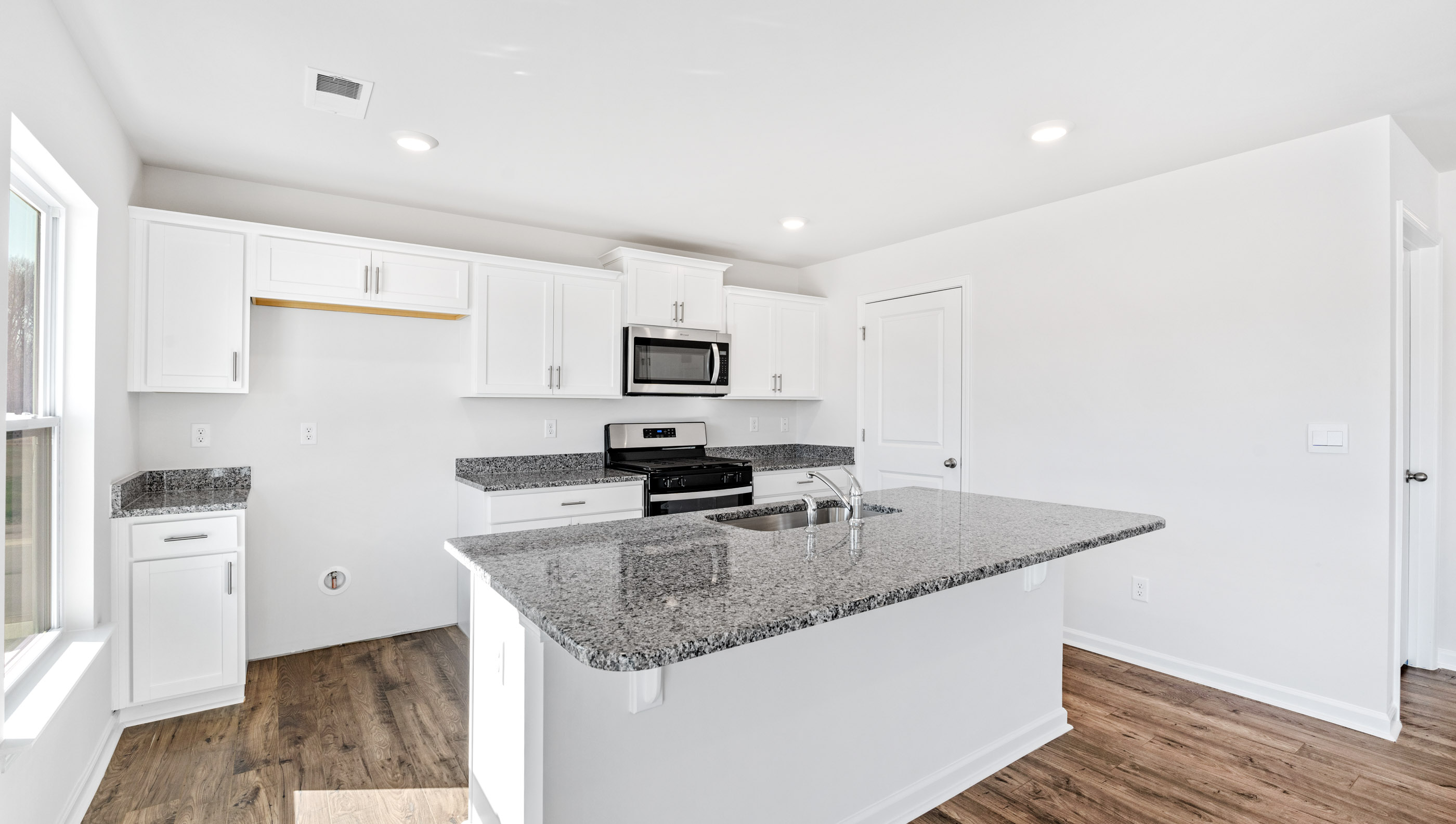 Kitchen and island with granite counter tops.
