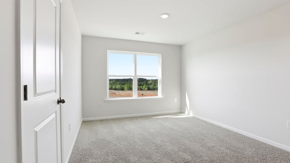 Bedroom with carpet and window.