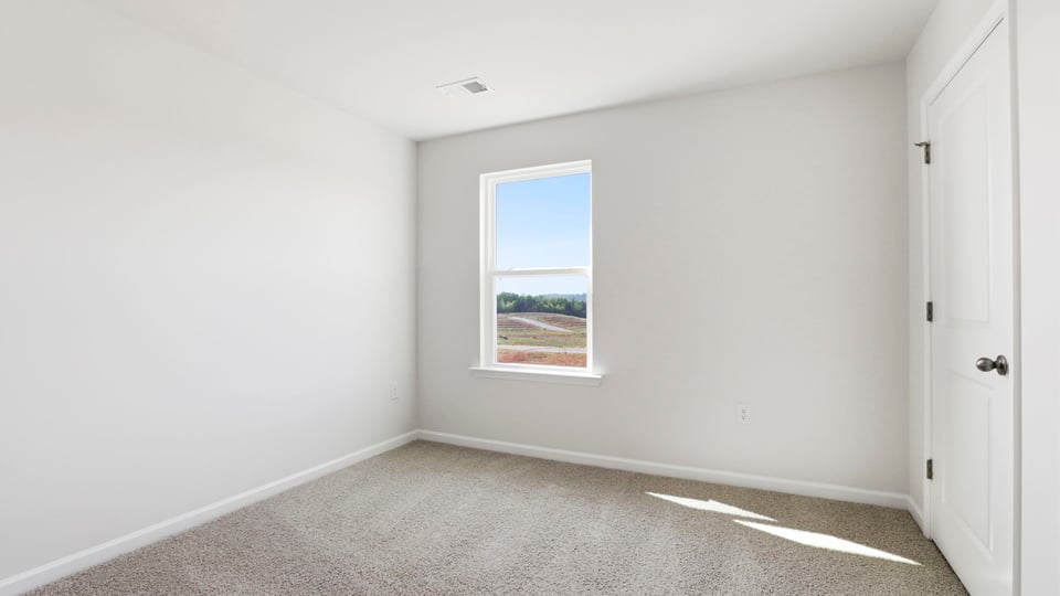 Bedroom with carpet and window.