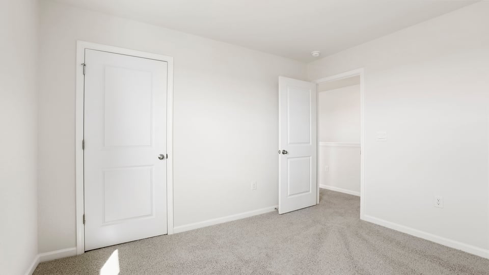 Bedroom with carpet and window.