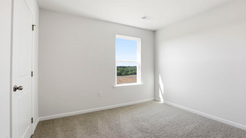 Bedroom with carpet and window.