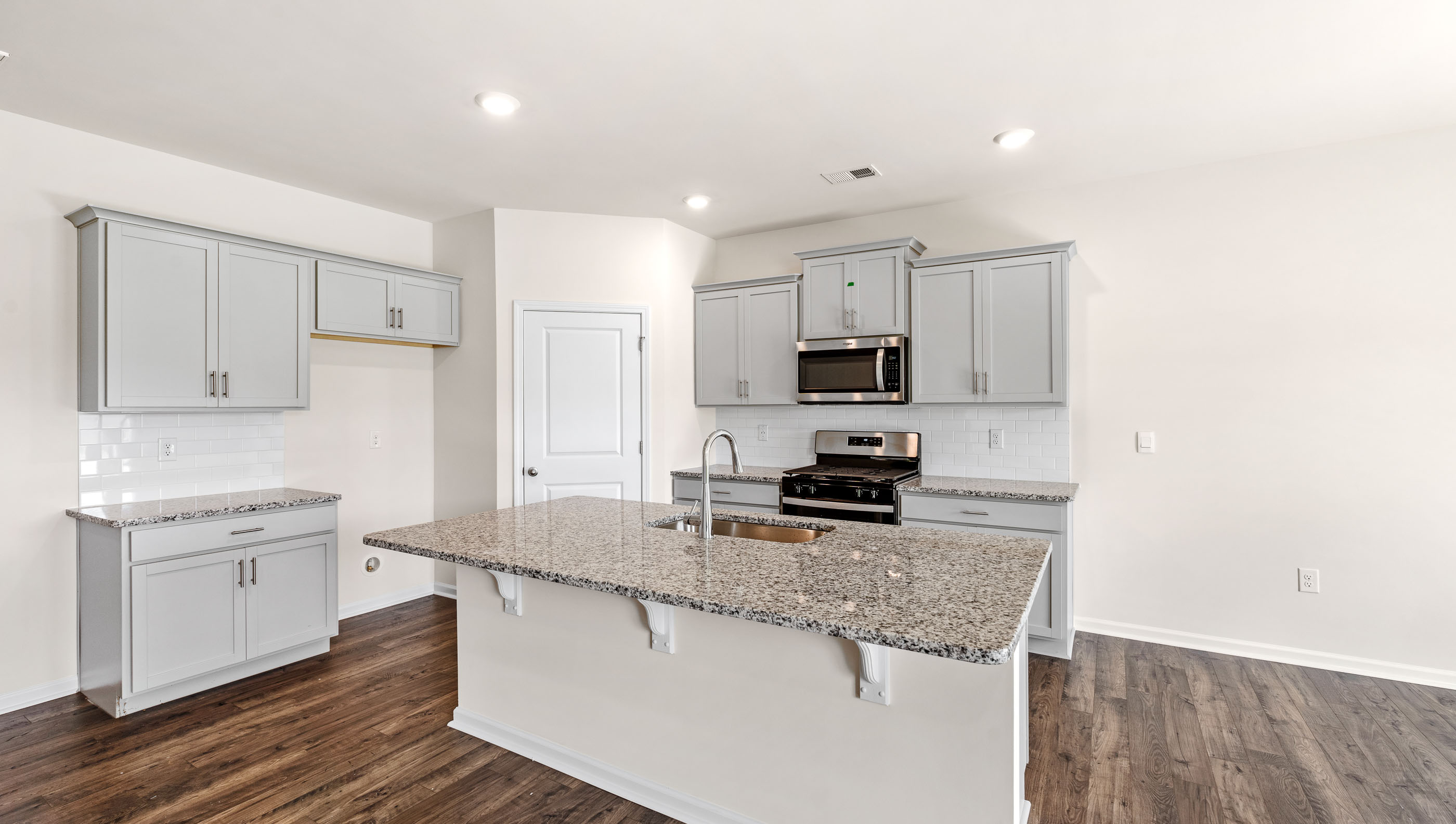 Kitchen with island with granite countertops.