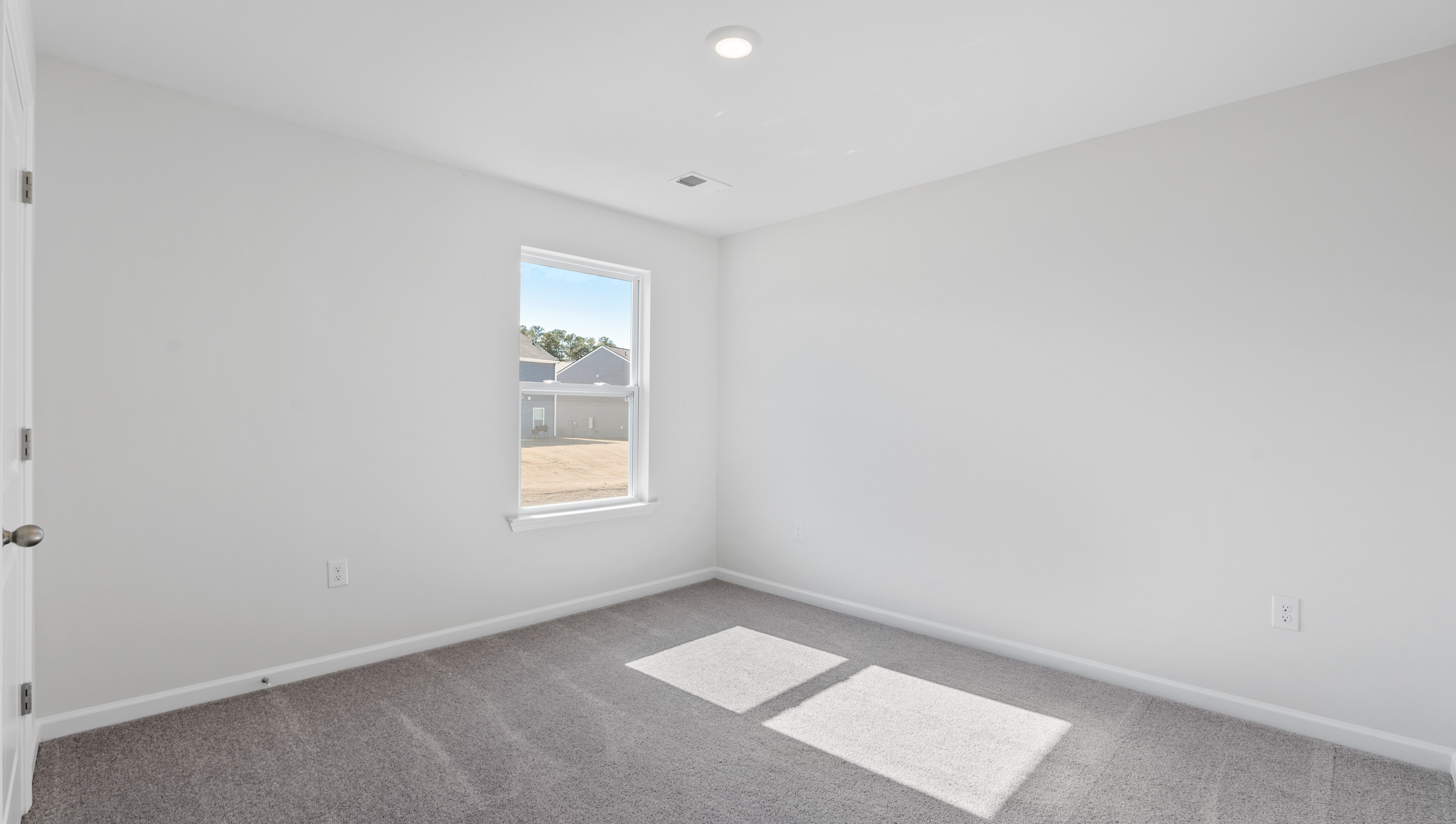 Bedroom with carpet and window.a
