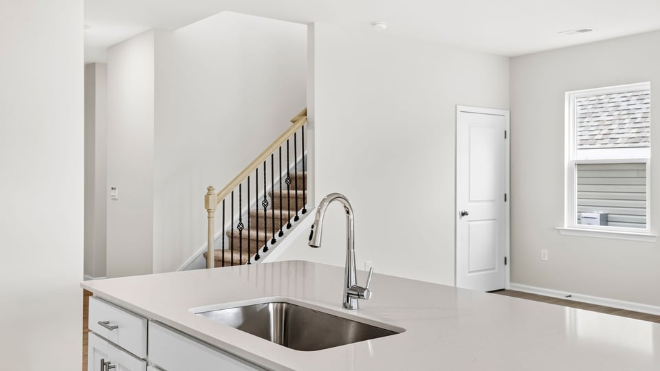 Kitchen view of sink/island and stairway