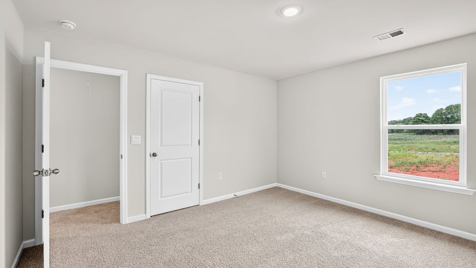 Upstairs bedroom with carpet, windows, closet, and doorway