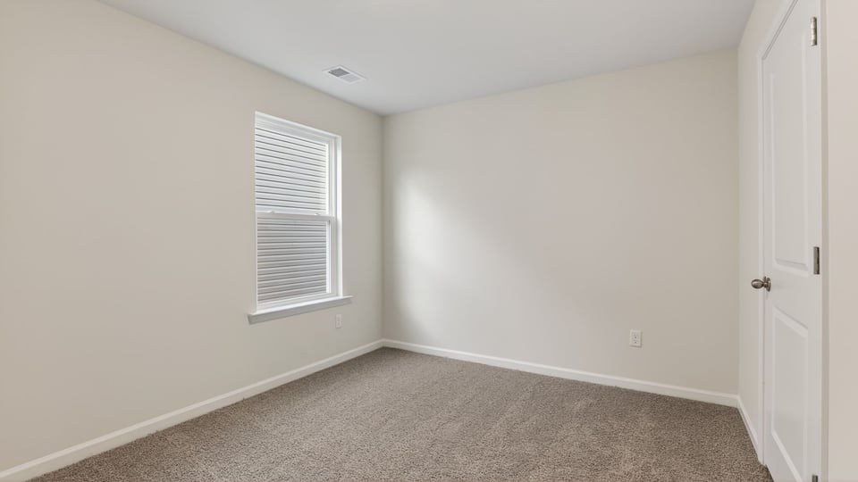 Bedroom with carpet and window.
