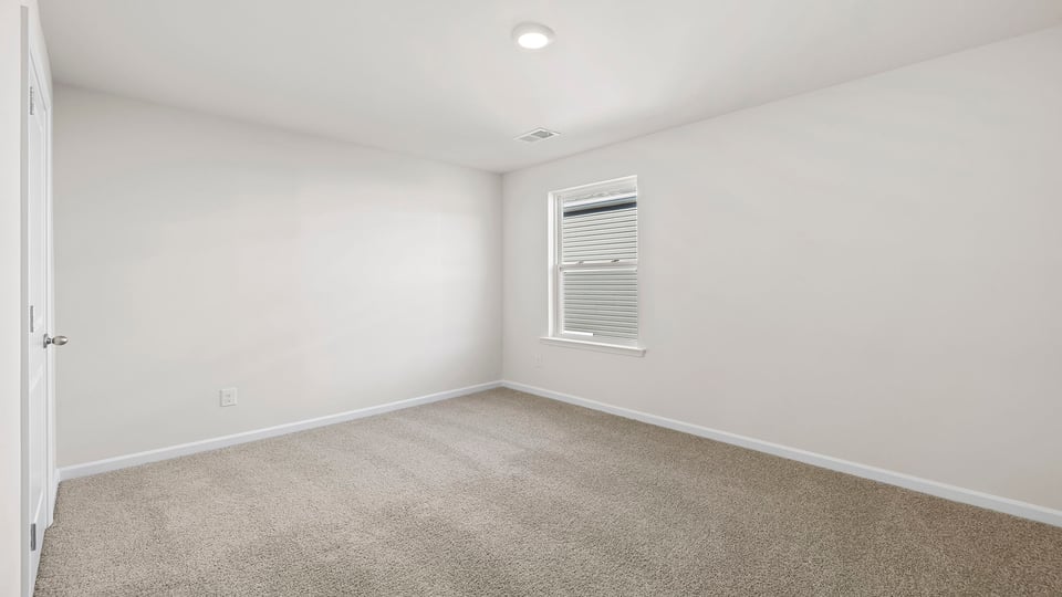 Bedroom with carpet and window.