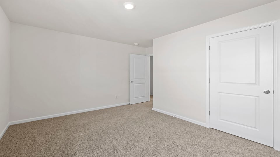 Bedroom with carpet and window.