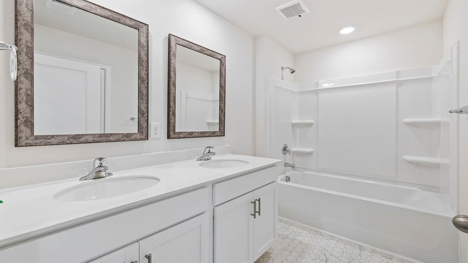 Bathroom with double vanity and walk in shower.
