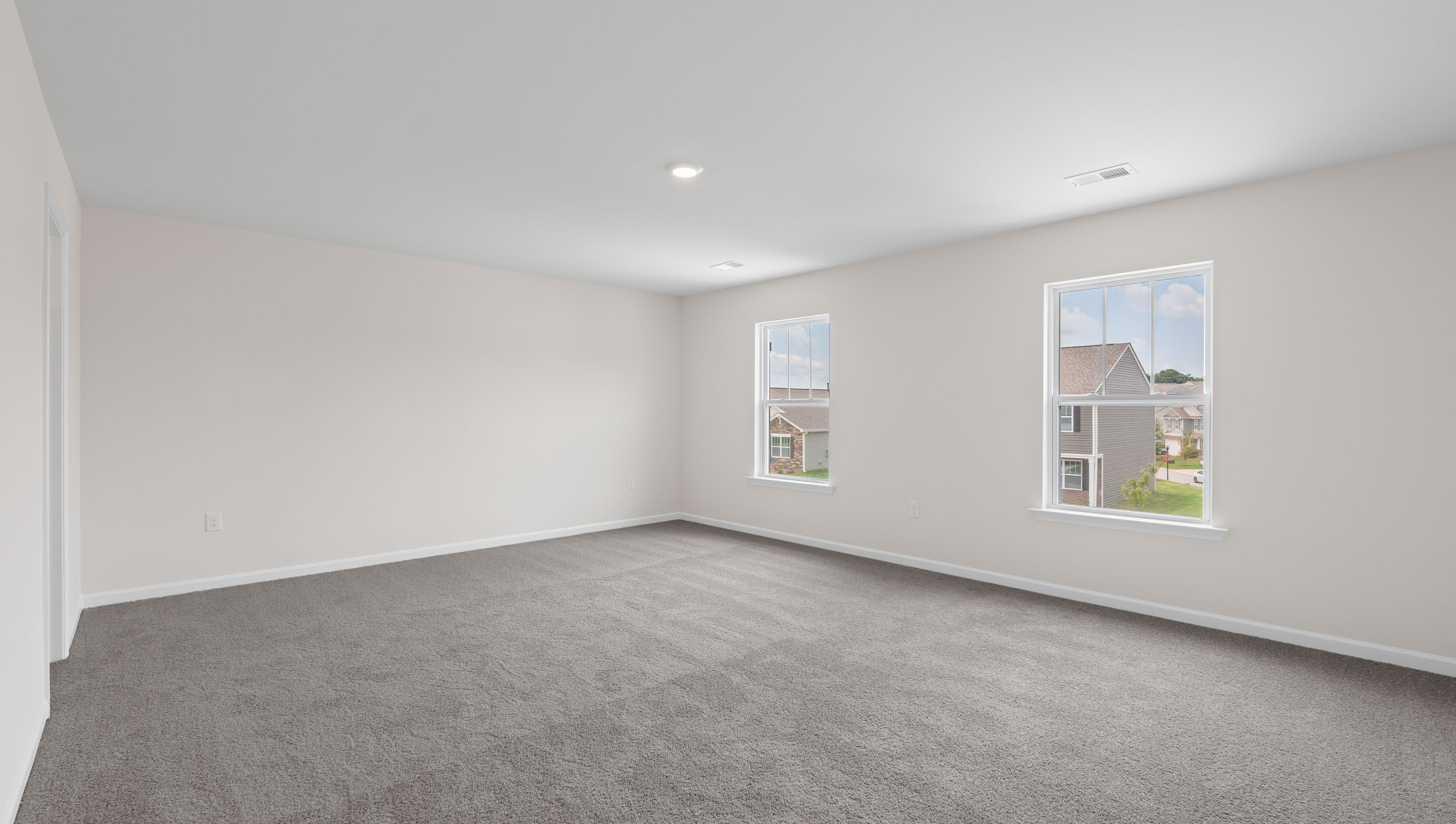 Bedroom with carpet and windows.