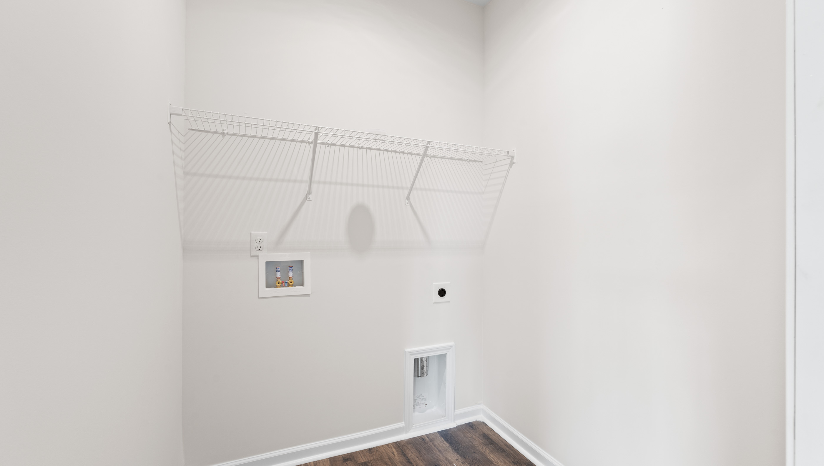 Laundry room with hanging storage shelves.