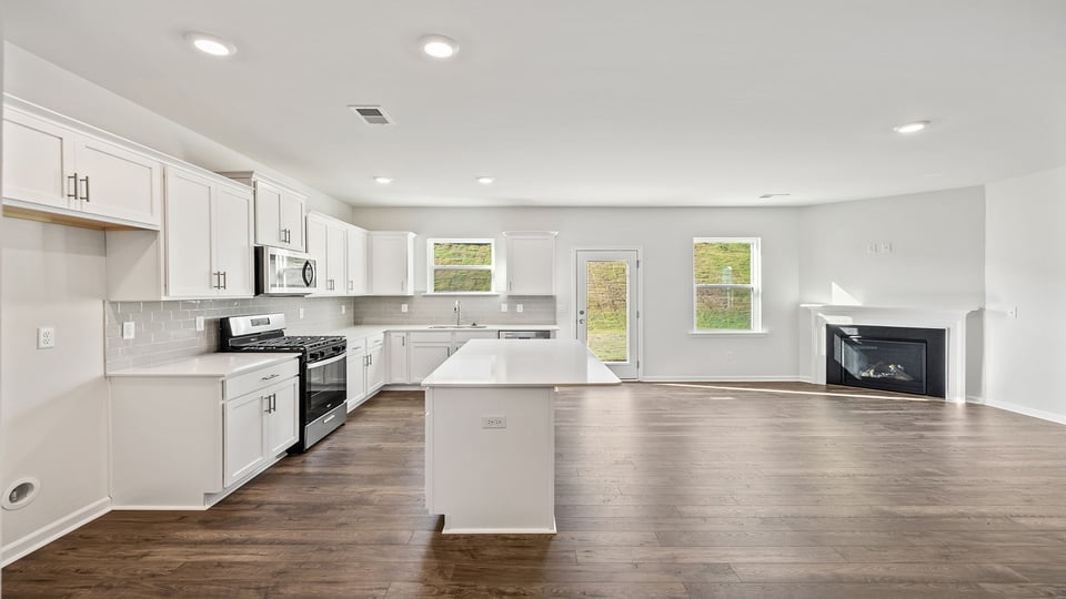Kitchen looking towards family room with fireplace.