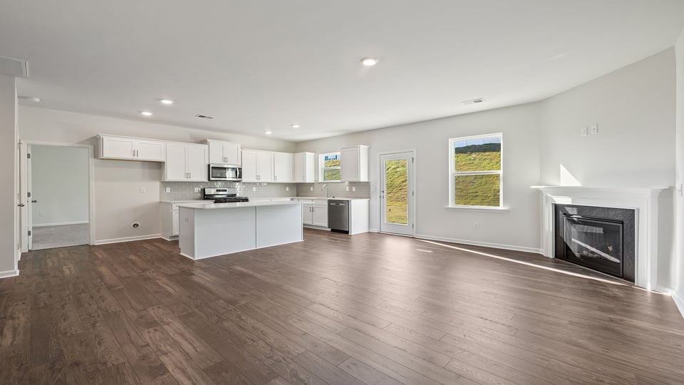 Living room with fireplace and view of kitchen.