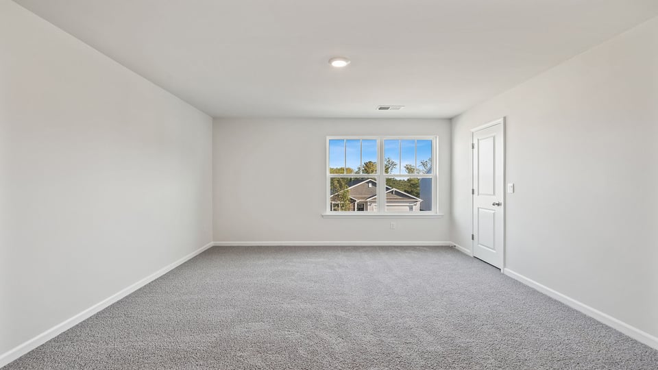 Bedroom with carpet and window.