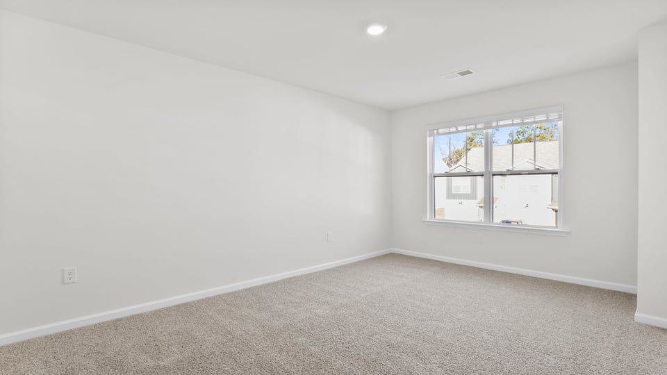 Bedroom with carpet and window.