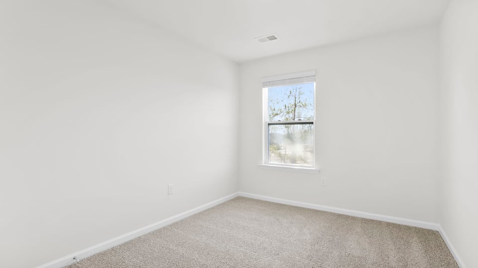 Bedroom with carpet and window.