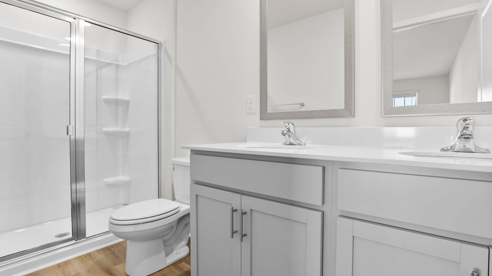 Bathroom with double vanity sink and walk in shower.