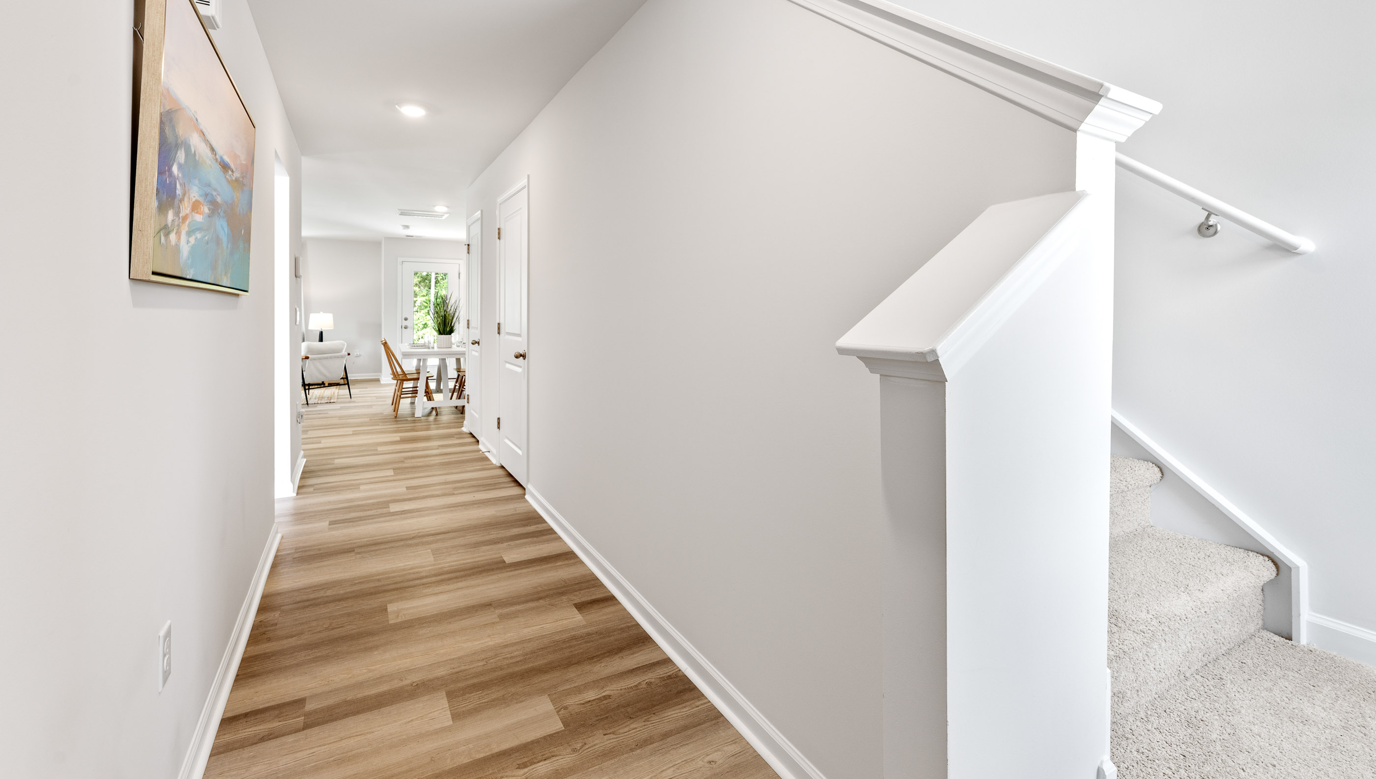 Hallway into home with view of stairs.